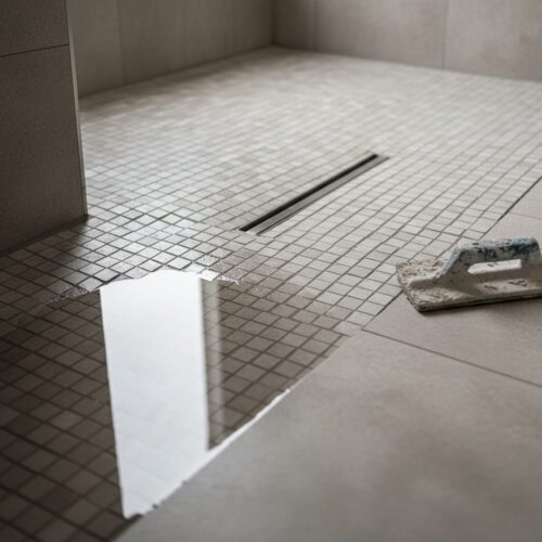 Mängelhaftung bei der Badsanierung: Stehendes Wasser zeigt das unzureichende Duschgefälle. Der Handwerker haftet für den Pfusch.