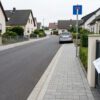 erschliessungsbeitragsbescheid-baugb Neu asphaltierte Sackgasse in einem Wohngebiet mit Bordsteinen und einem offiziellen Brief im Briefkasten.